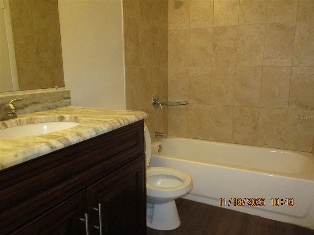 291 Flower Lane, Unit A Kissimmee, FL 34743 - Photo 38 of 40 a bathroom with a granite countertop sink toilet and bathtub