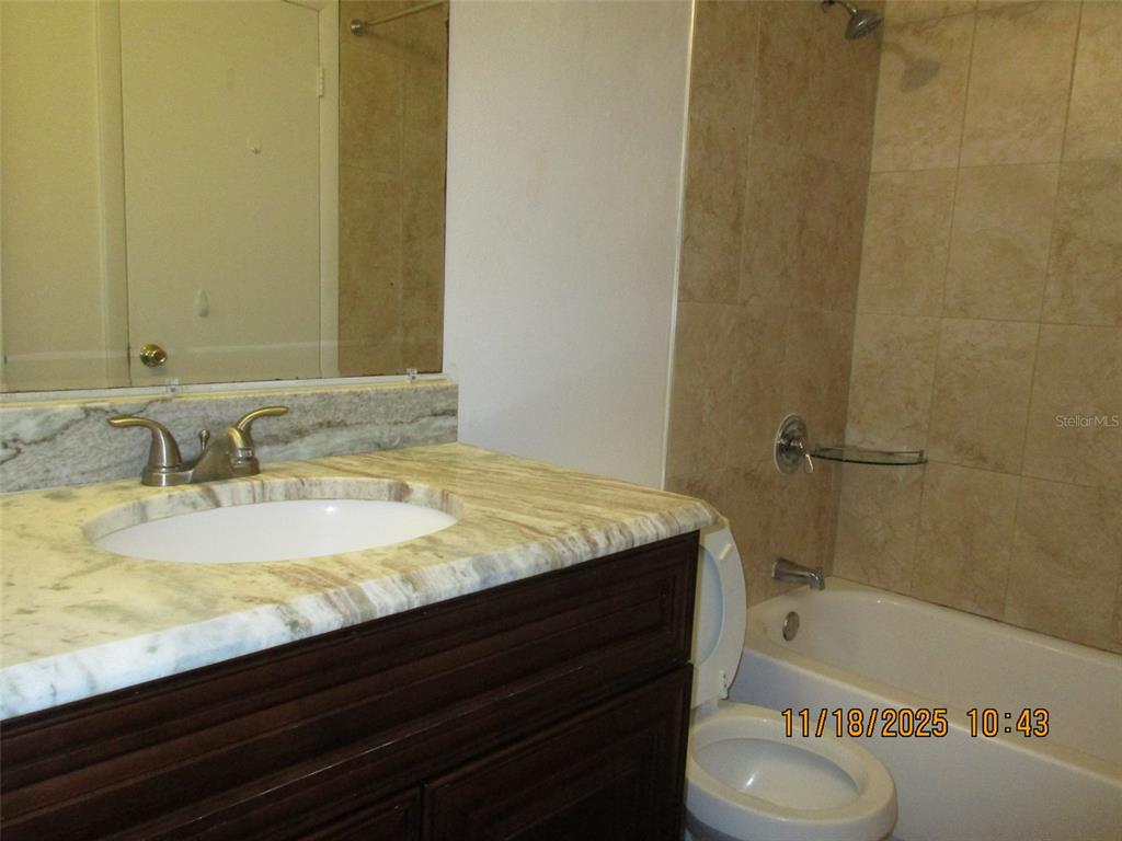 291 Flower Lane, Unit A Kissimmee, FL 34743 - Photo 40 of 40 a bathroom with a granite countertop sink and a bathtub