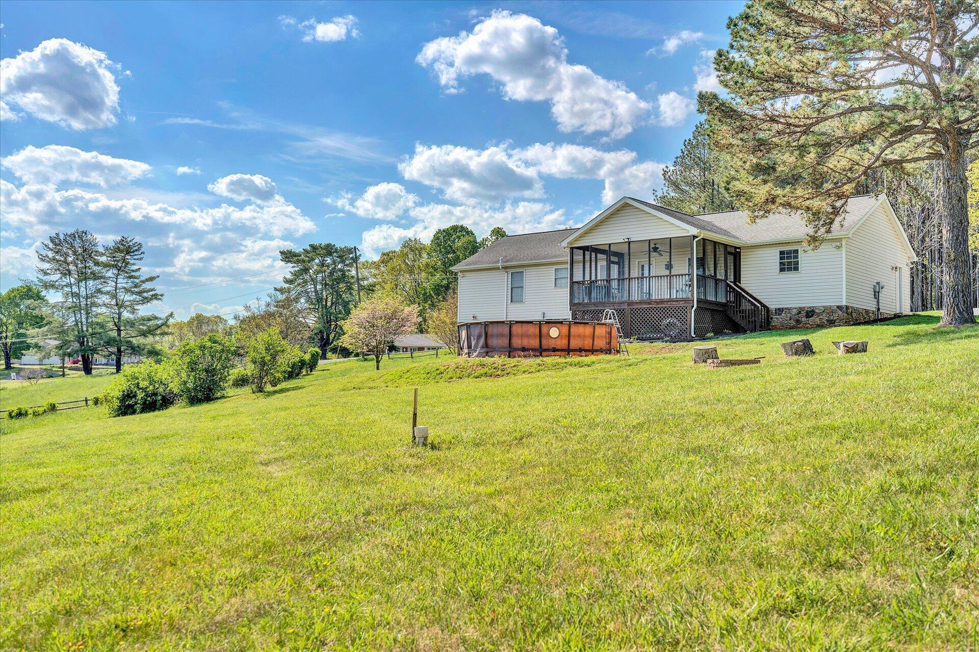 1306 Turner Branch Road Goodview, VA 24095 - Photo 2 of 21 a yellow house with a yard and a large tree