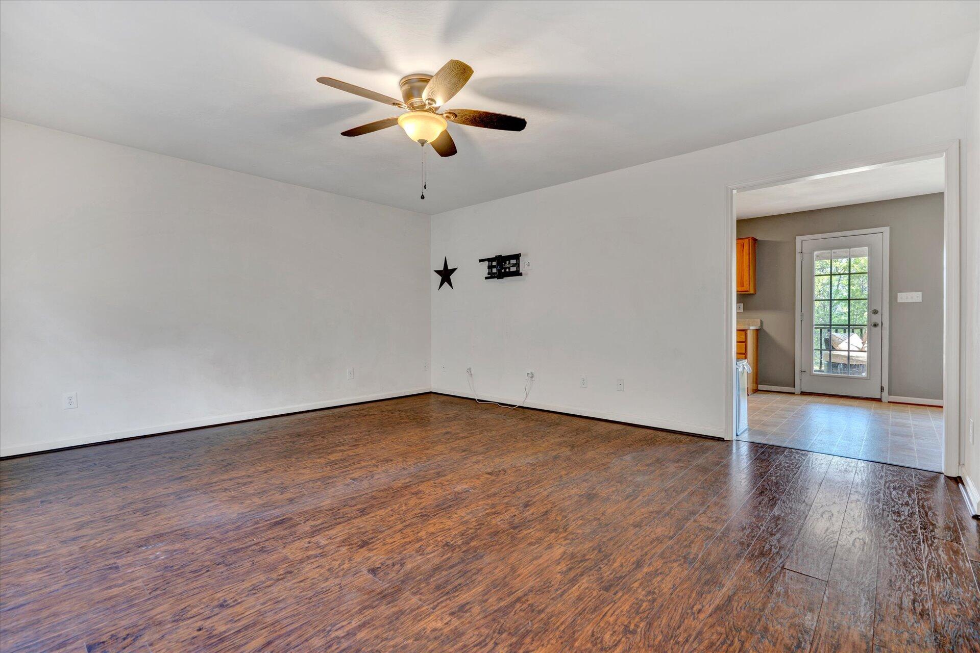 1306 Turner Branch Road Goodview, VA 24095 - Photo 4 of 21 an empty room with wooden floor and windows