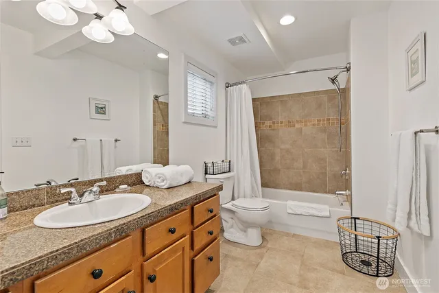 a bathroom with a granite countertop sink mirror toilet and shower
