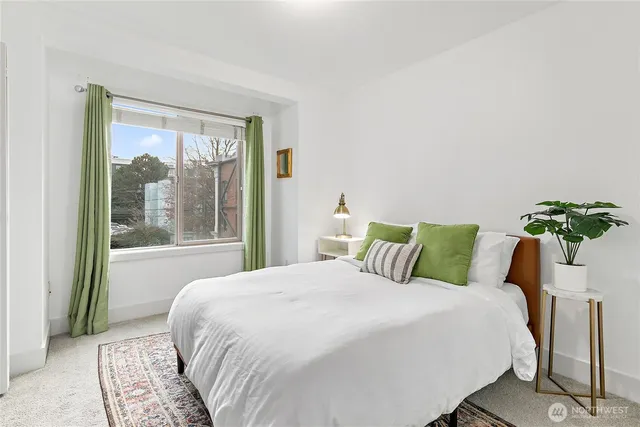 a bedroom with a large bed and a potted plant