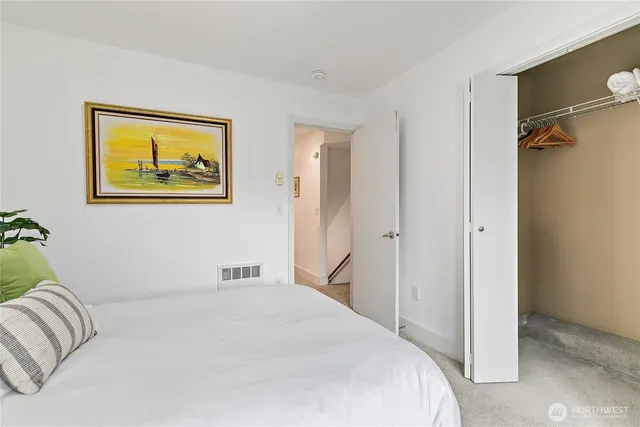 a bedroom with a bed and a painting on the wall