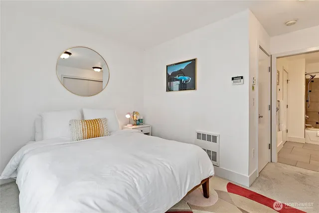 a bedroom with a bed and a painting on the wall