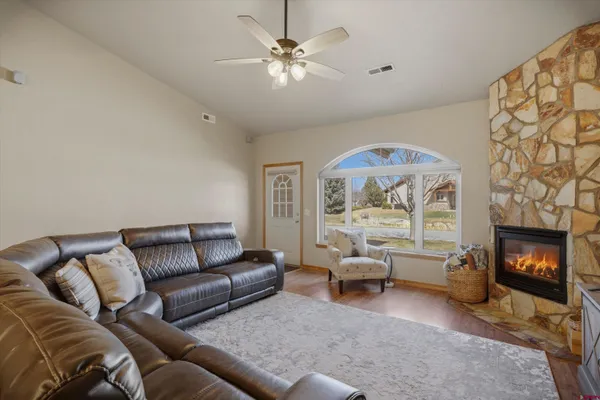 a living room with furniture a flat screen tv and a fireplace