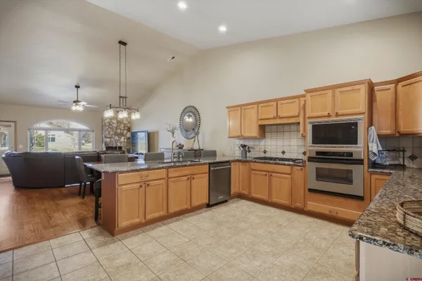 a dining hall with stainless steel appliances granite countertop a dining table and chairs