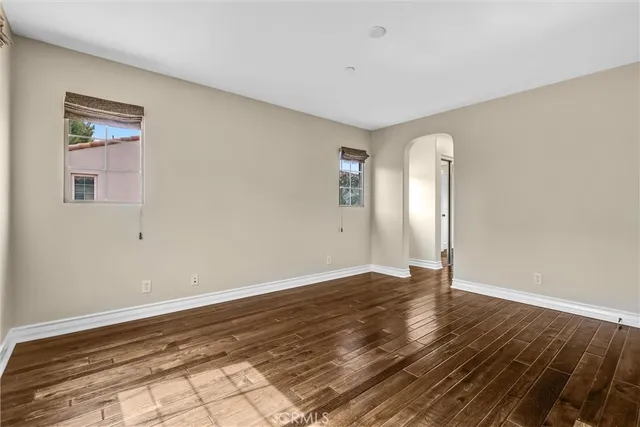 a view of an empty room with window and wooden floor