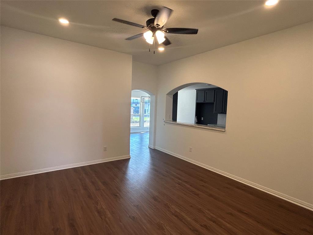 412 Conway Street Waco, TX 76705 - Photo 3 of 8 Empty room featuring arched walkways, dark wood-type flooring, ceiling fan, and recessed lighting