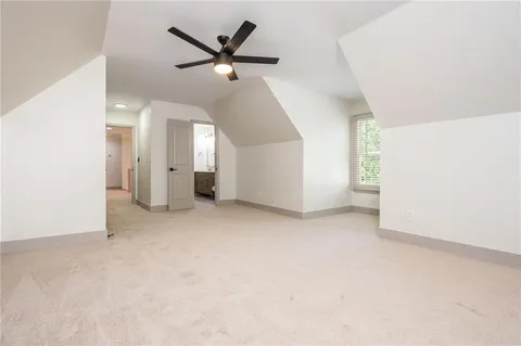 an empty room with a ceiling fan and window