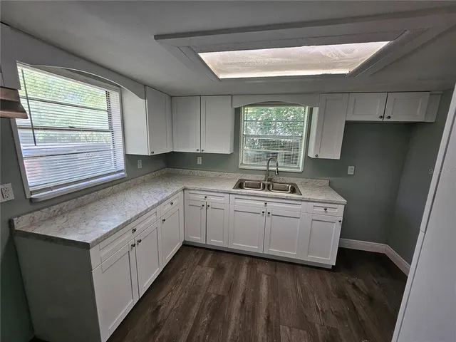 a kitchen with sink a window and refrigerator