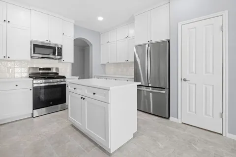 a kitchen with stainless steel appliances a refrigerator stove and microwave