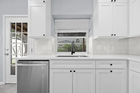 a kitchen with white cabinets and a sink