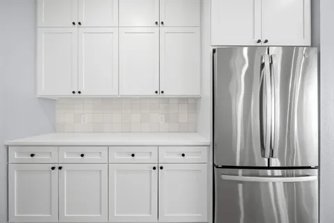 a view of kitchen with refrigerator and cabinet