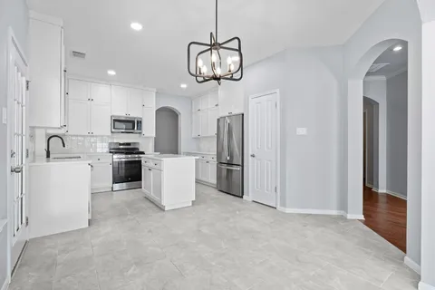 a view of a kitchen with sink stove and white cabinets