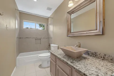 a bathroom with a granite countertop sink a toilet and a mirror