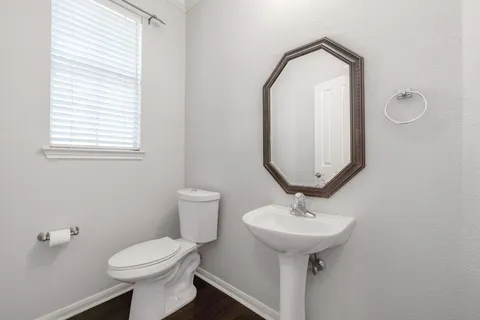 a bathroom with a toilet sink and mirror