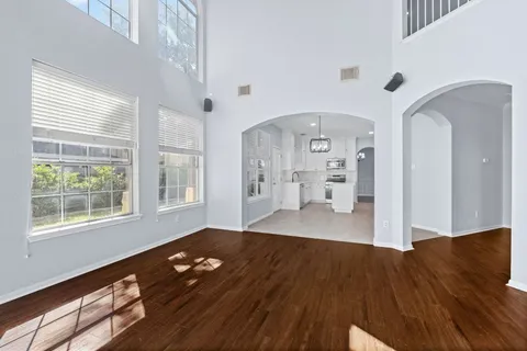 a view of a living room with wooden floor and a large window