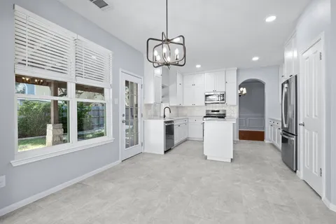 a view of a kitchen with refrigerator and windows