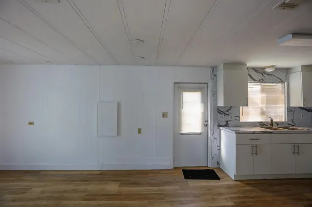a view of a kitchen with wooden floor and cabinets