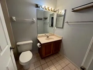 a bathroom with a sink vanity mirror and toilet