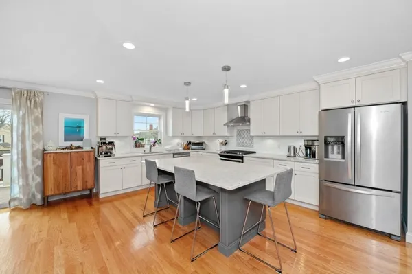a kitchen with a sink a stove a refrigerator and white cabinets with wooden floor