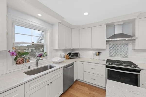 a kitchen with white cabinets and appliances