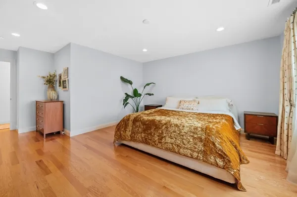 a spacious bedroom with a bed and a chair in it