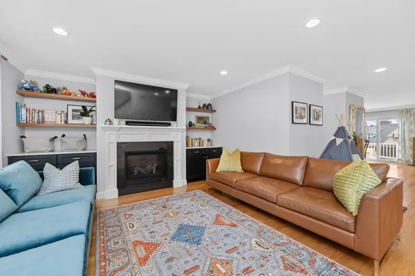 a living room with furniture a flat screen tv and a fireplace