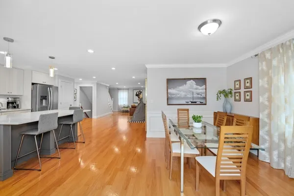 a dining room with wooden floor a glass table and chairs