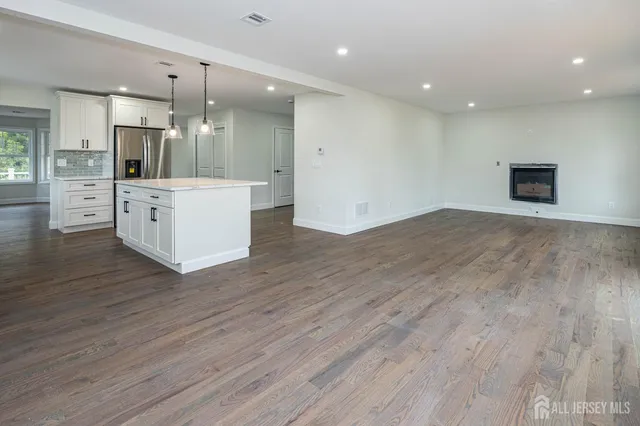 a view of kitchen with cabinets appliances and wooden floor