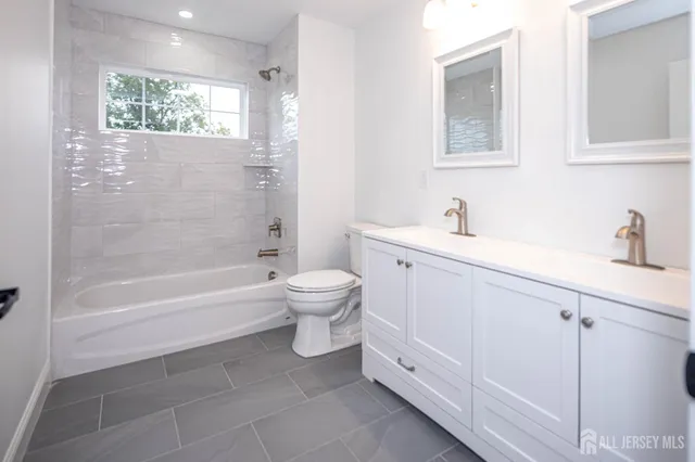 a bathroom with a bathtub sink mirror and toilet