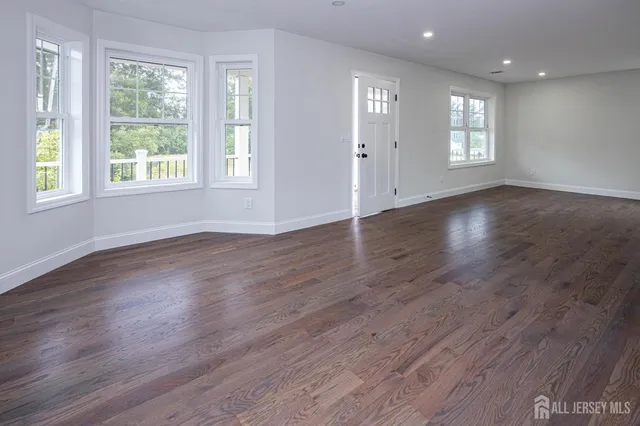 an empty room with wooden floor and window