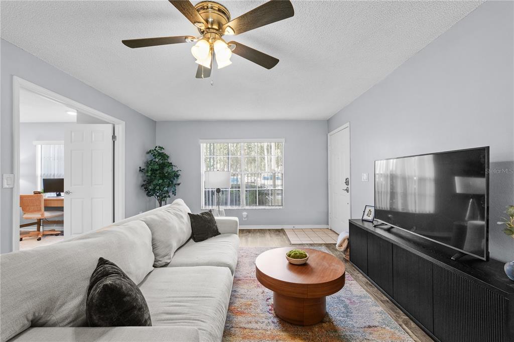 4515 Whitton Way, Unit 117 New Port Richey, FL 34653 - Photo 11 of 35 a living room with furniture a window and a chandelier
