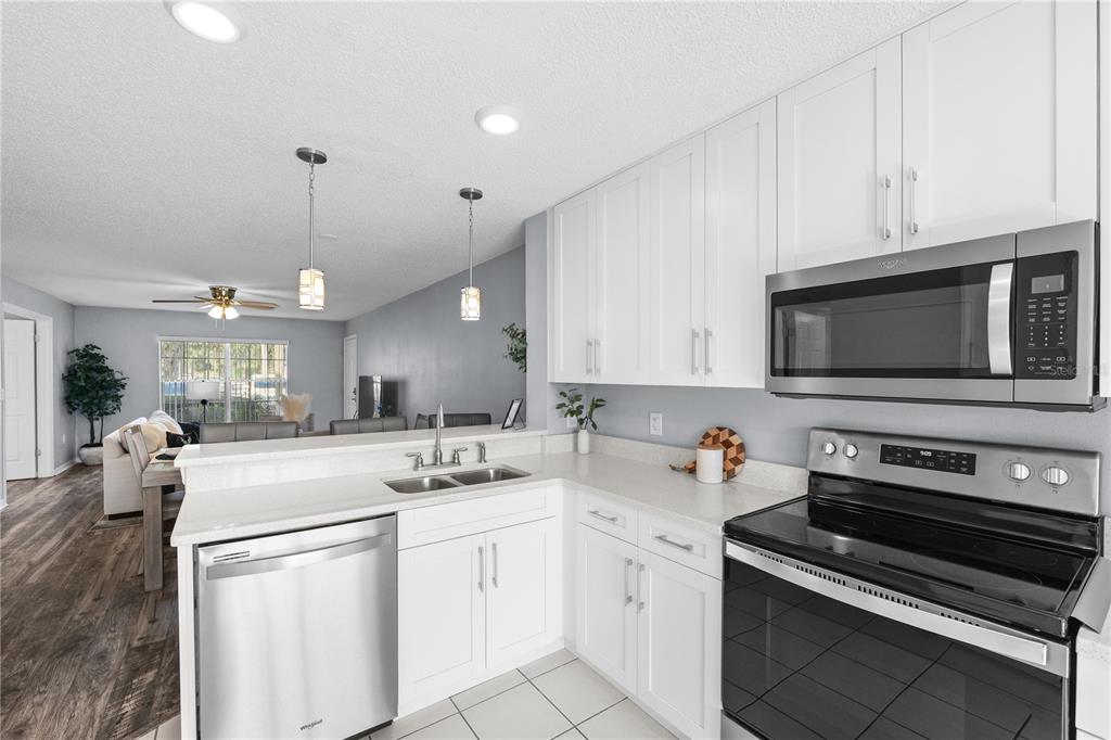 4515 Whitton Way, Unit 117 New Port Richey, FL 34653 - Photo 16 of 35 a kitchen with stainless steel appliances a stove a sink and a microwave