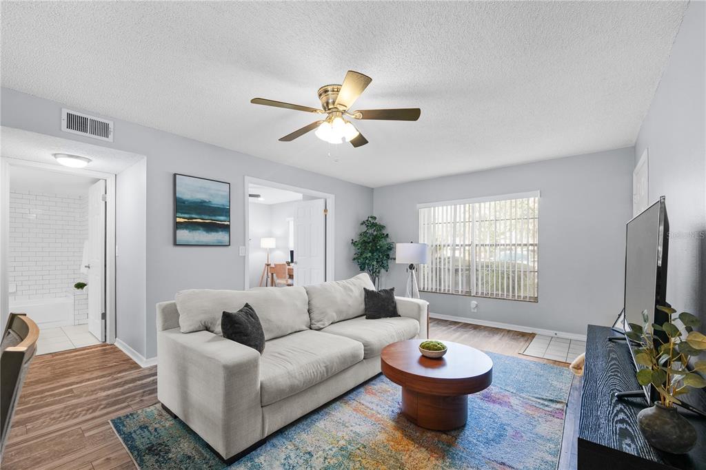 4515 Whitton Way, Unit 117 New Port Richey, FL 34653 - Photo 8 of 35 a living room with furniture a chandelier and a window