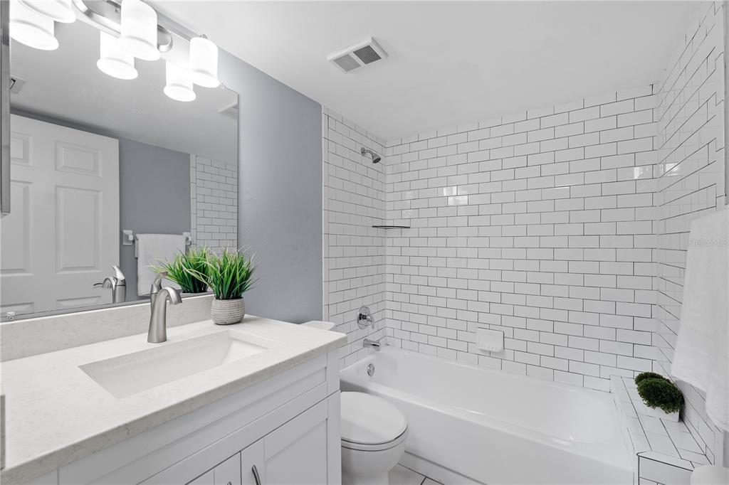 4515 Whitton Way, Unit 117 New Port Richey, FL 34653 - Photo 9 of 35 a bathroom with a sink a toilet a mirror and shower