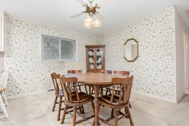 a large white kitchen with a white stove a dining table and chairs