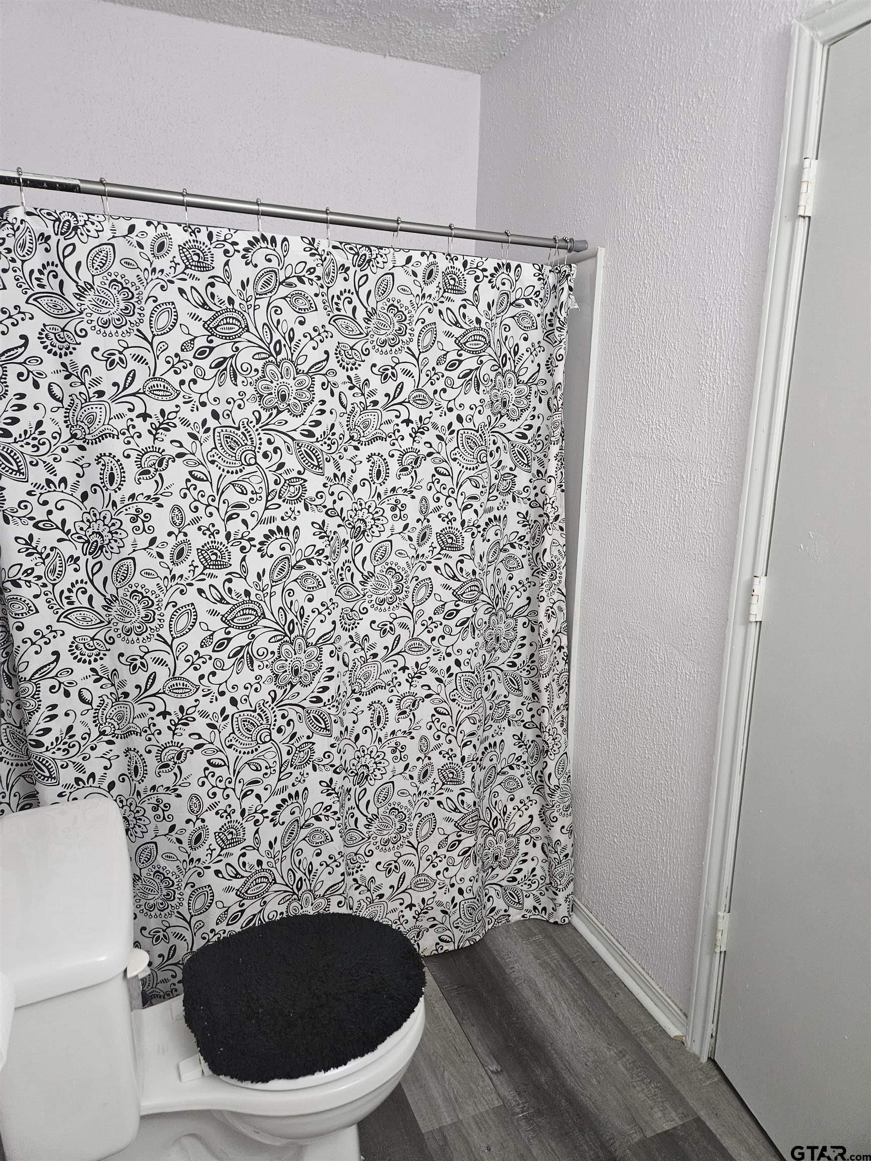 3309 North Luberta Street Tyler, TX 75702 - Photo 6 of 14 a bathroom with a toilet and a shower curtain