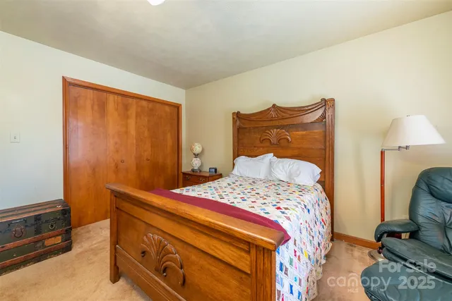 a bedroom with a bed a dresser and flat screen tv