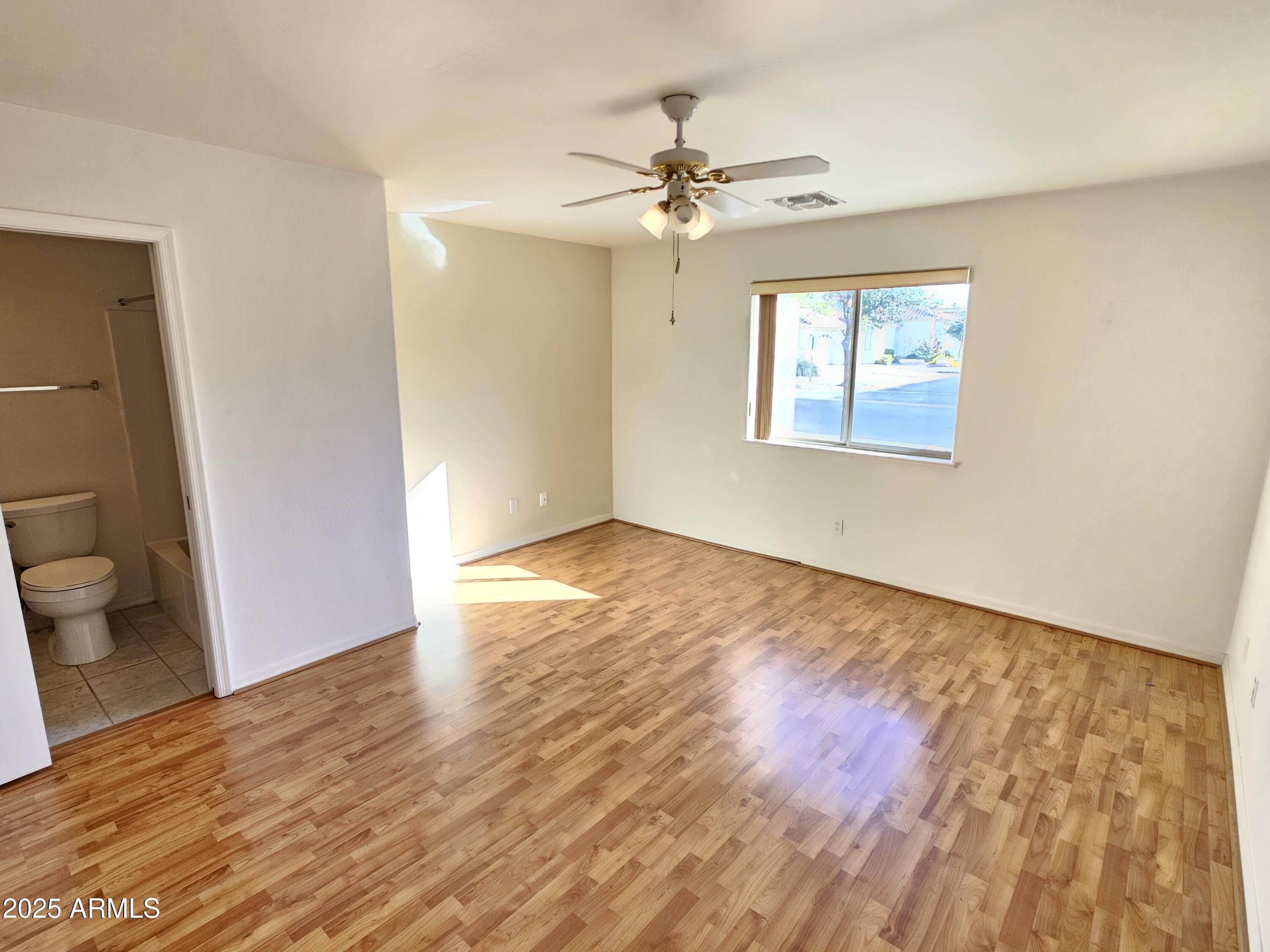 5830 East McKellips Road, Unit 139 Mesa, AZ 85215 - Photo 25 of 53 a view of an empty room with wooden floor and a window