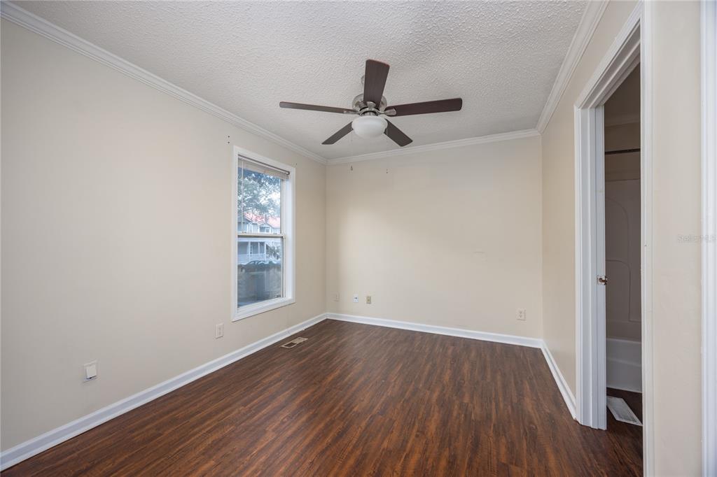 2905 Southwest Archer Road, Unit S4024 Gainesville, FL 32608 - Photo 13 of 19 an empty room with wooden floor ceiling fan and windows