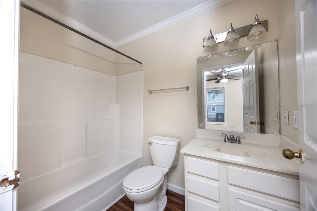 2905 Southwest Archer Road, Unit S4024 Gainesville, FL 32608 - Photo 15 of 19 a bathroom with a toilet a sink a mirror a shower a vanity and window
