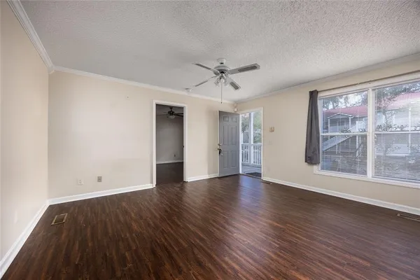 an empty room with wooden floor and windows