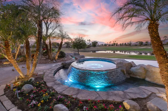 a view of a swimming pool with a patio and a yard