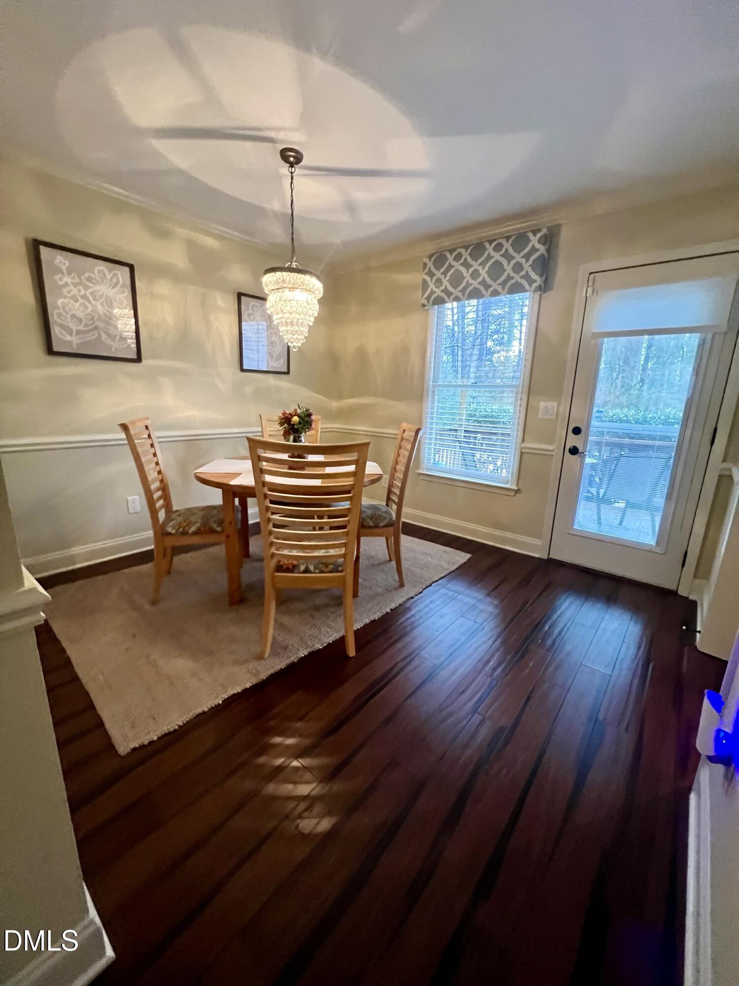 710 Powell Drive, Unit C Raleigh, NC 27606 - Photo 13 of 35 a dining room with wooden floor a chandelier a glass table and chairs