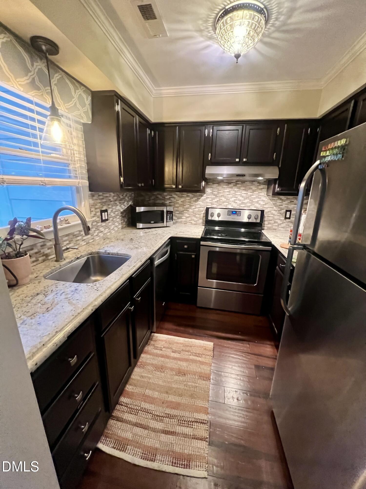 710 Powell Drive, Unit C Raleigh, NC 27606 - Photo 15 of 35 a kitchen with stainless steel appliances granite countertop a sink stove and cabinets