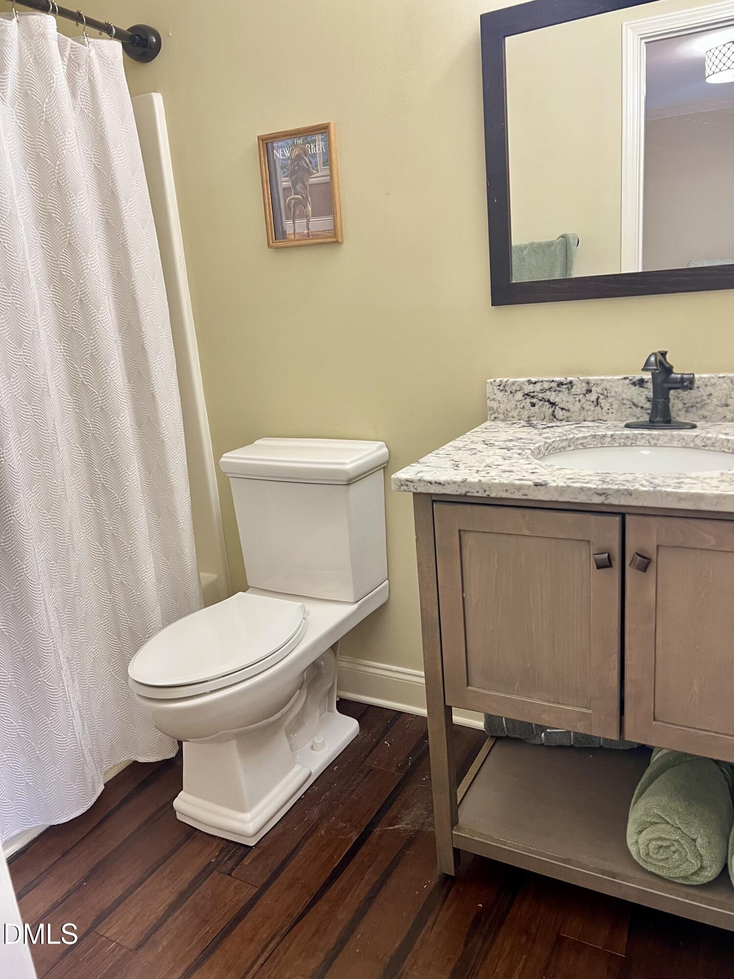 710 Powell Drive, Unit C Raleigh, NC 27606 - Photo 24 of 35 a bathroom with a granite countertop toilet sink and a mirror