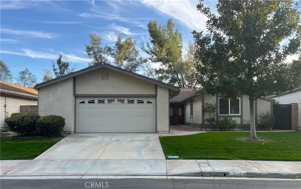 a front view of a house with a garden and plants