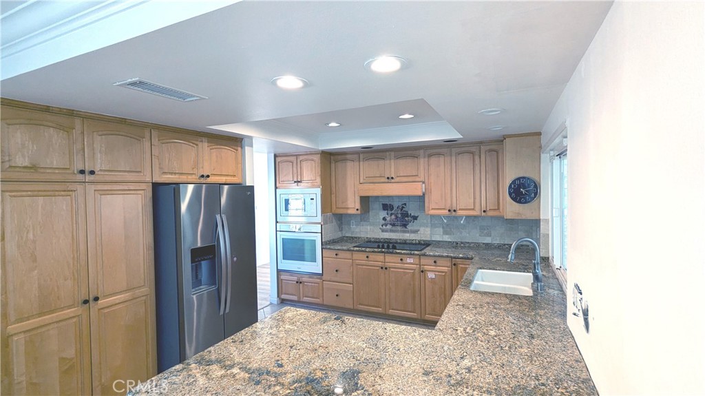 718 Vía La Paloma Riverside, CA 92507 - Photo 7 of 26 a kitchen with stainless steel appliances granite countertop a refrigerator and a sink