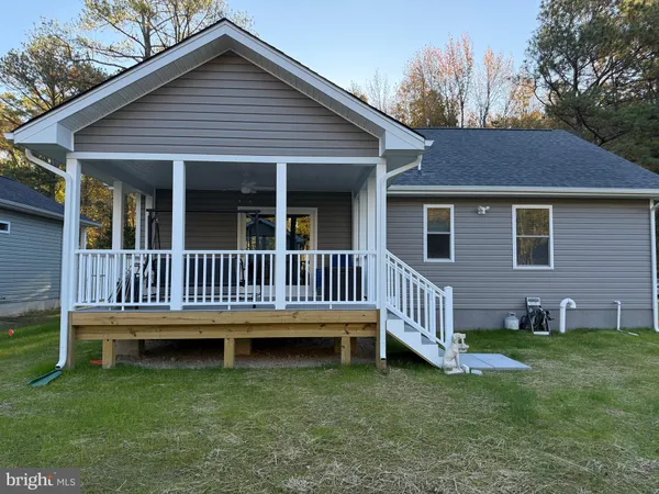 a front view of a house with a yard and trees